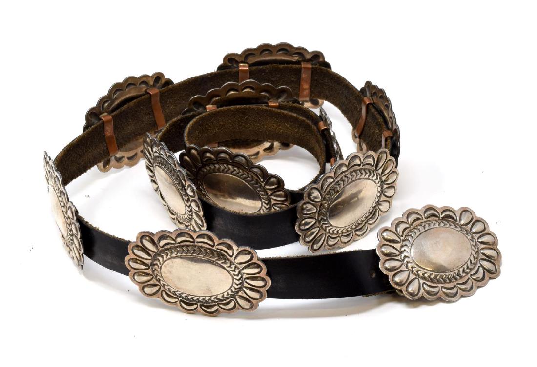 ROBERT JOHNSON NAVAJO STERLING CONCHO BELT: Southwest Native American sterling silver concho belt, signed RJ (Robert Johnson, Navajo), the leather belt accompanied by (1) buckle (marked) and (10) conchos, each with copper looks to back, leather