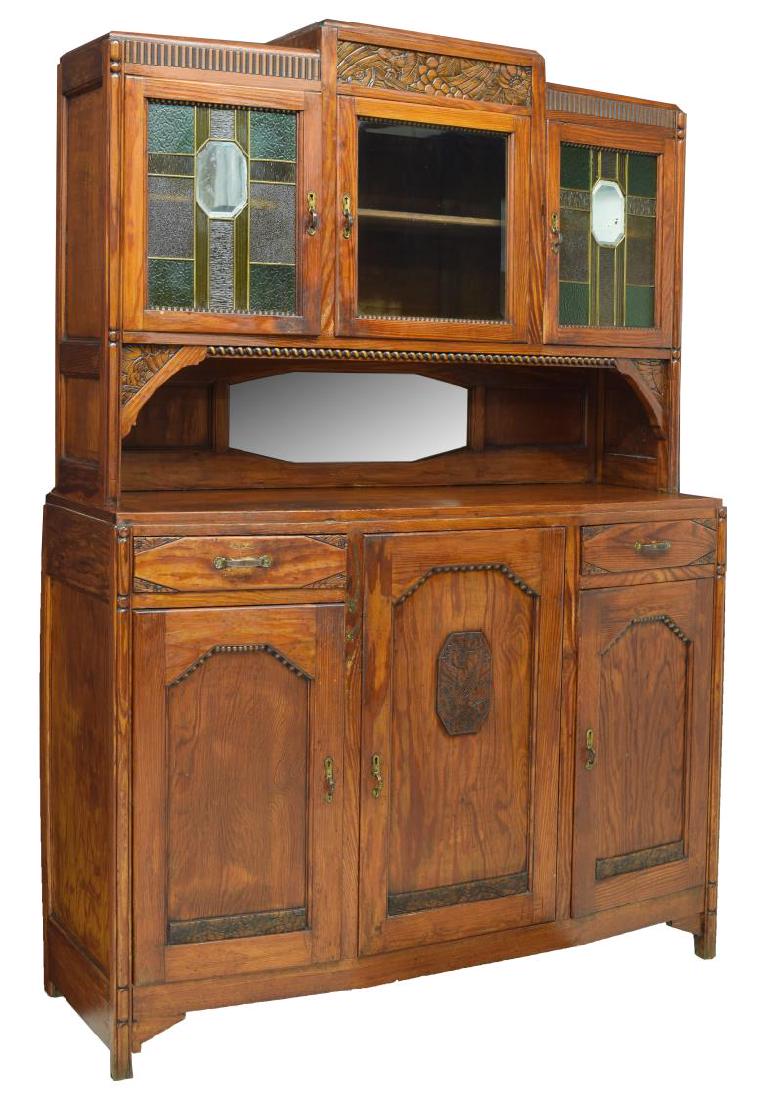 ART DECO OAK SIDEBOARD: Art Deco oak sideboard, c. 1930s-1940s, having three cabinets with stained glass doors, over rectangular case fitted with two drawers and three cabinets, center cabinet door with stylized floral medal