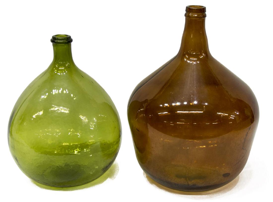 (2) VINTAGE GLASS WINE BOTTLES: (lot of 2) Vintage glass wine bottles, molded form, with thin neck, over bulbous body, (one) green, (one) amber, largest: approx 17"h, 12.5"diam; 13.5lbs total Start Price: $50.00