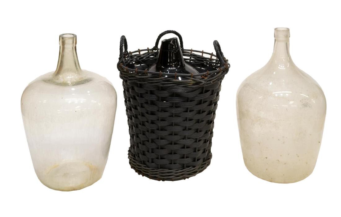 (3) BORDEAUX CLEAR & COLORED GLASS WINE BOTTLES: (lot of 3) Bordeaux glass bottles, 19th c., including: (2) of clear glass, (1) of colored glass, with loss to rim, largest: approx 27.5"h, 16.5"diam Start Price: $200.00