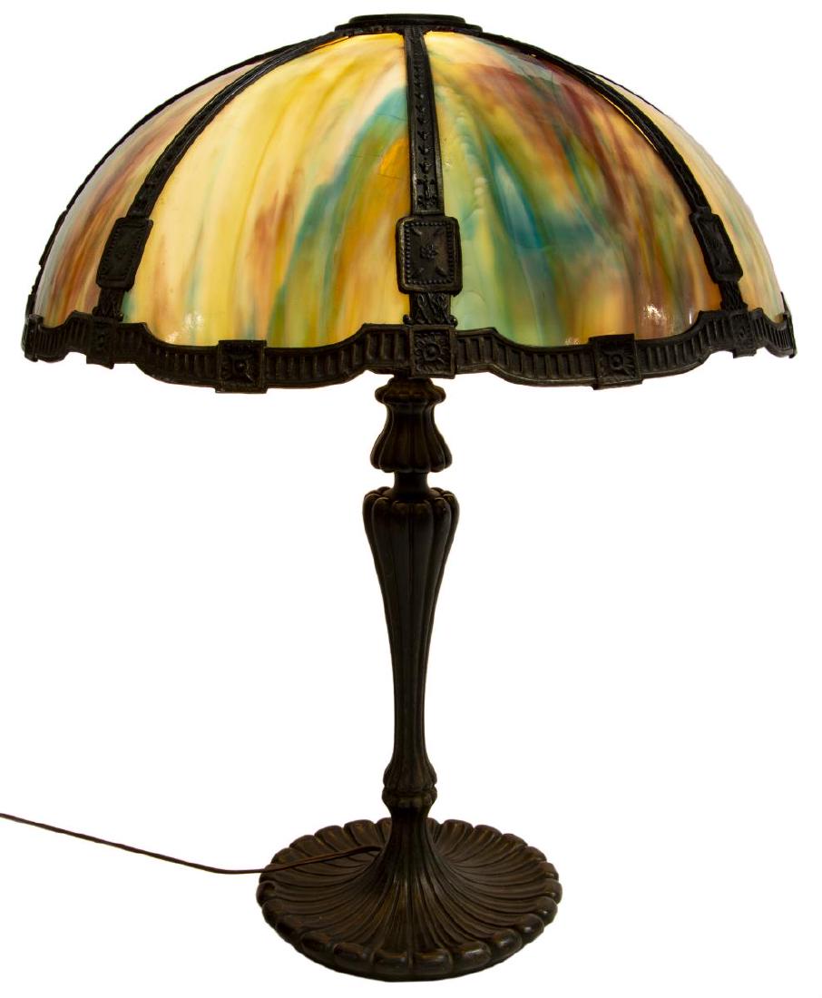 AMERICAN PATINATED METAL & SLAG GLASS TABLE LAMP: Fine American slag glass and metal table lamp, early 20thc, the large domed shade fitted with eight colorful panels held by floral and foliate metal frame, single light, on the ribbed base on upturned