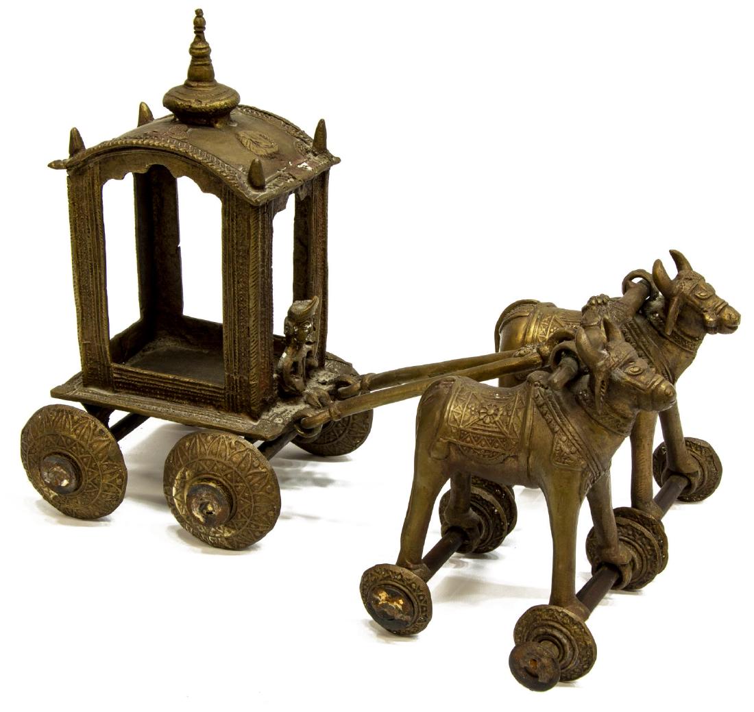 INDIA BRONZE FIGURAL TEMPLE TOY, OXEN & CART: Bronze figural temple toy, India, modeled as two oxen pulling a ceremonial cart with seated driver, 11"h, 14"l, 10"w, 11.25lbs Start Price: $80.00