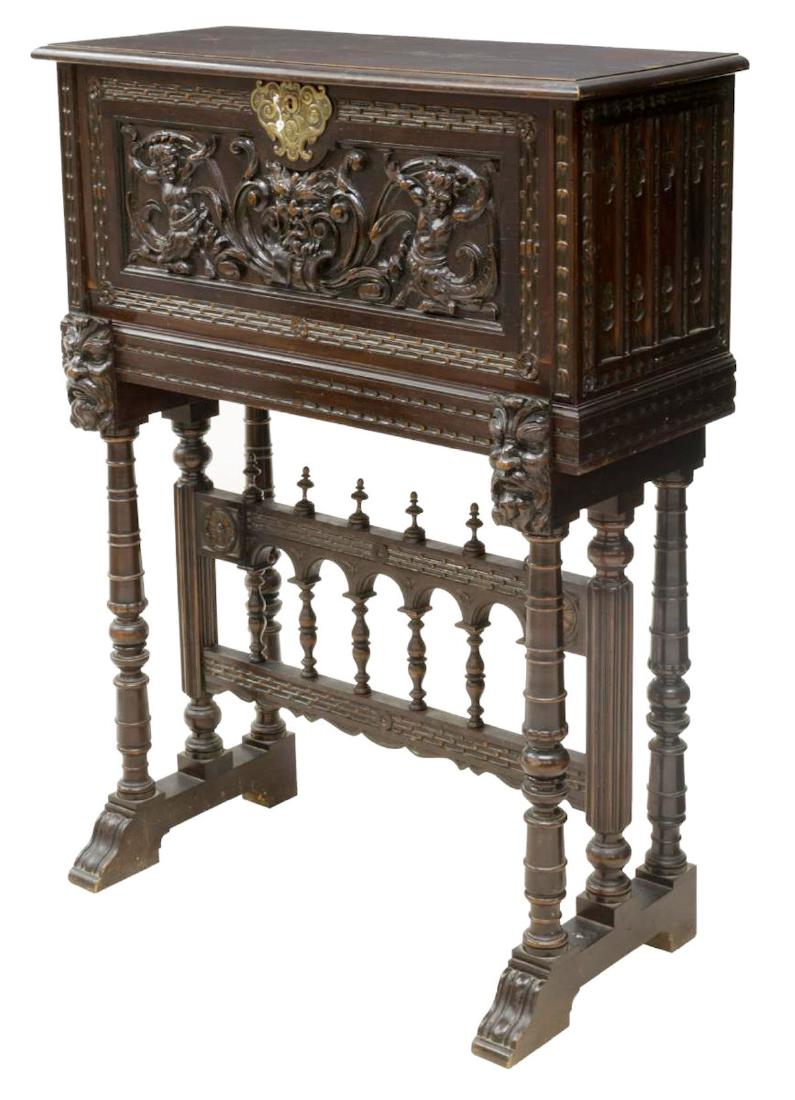NORTHERN SPAIN RENAISSANCE REVIVAL VARGUENO: Renaissance Revival vargueno on stand, Northern Spain, 19th c., the fall front with carved figures, foliage and a central mask opening on mask carved slides to a fitted interior, resting on a carved t