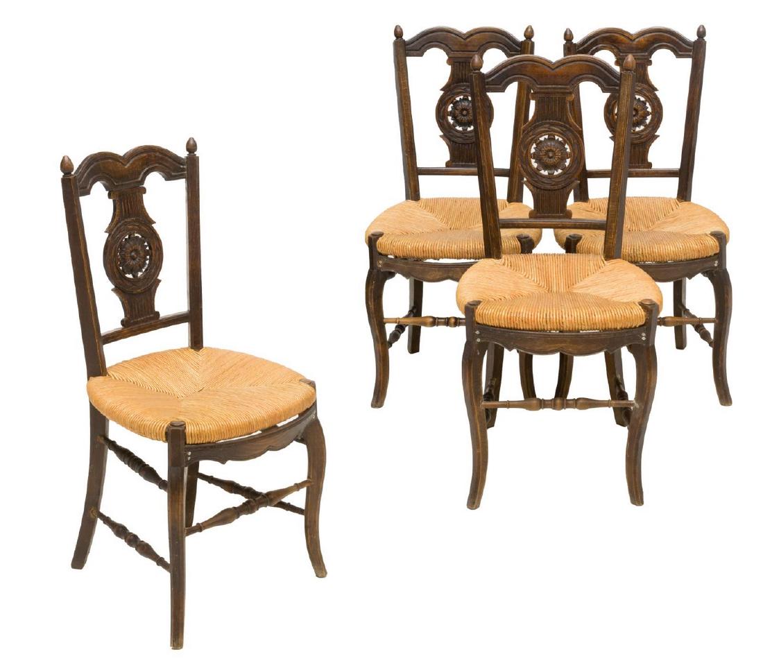 (4) FRENCH PROVINCIAL CARVED RUSH SEAT CHAIRS: (lot of 4) French provincial chairs, 20th c., the rosette carved backs rising above rush seats, resting on turned stretcher joined legs, one with restoration to finial, approx 37.5"h, 18.25"w, 17.5"d 