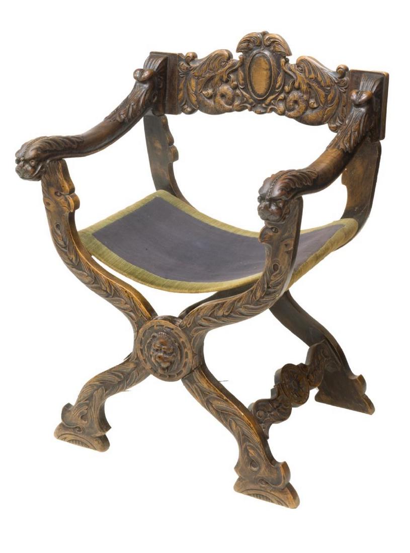 CONTINENTAL ORNATELY CARVED CURULE CHAIR: Continental ornately carved curule chair, having elaborate carved design of dolphins, grotesques, foliate and floral motifs to back rest and body, with arms ending in dragon head hand holds, rising on