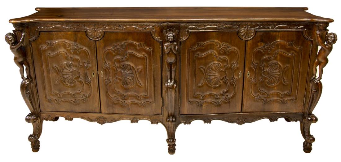 LARGE ITALIAN ROCAILLE NUDE PUTTI SIDEBOARD: Italian figural carved sideboard, early 20thc., the long, shaped top with molded edge, over robust nude full body putti figures to each end, rocaille carved cabinet doors enclose shelves and pull out 
