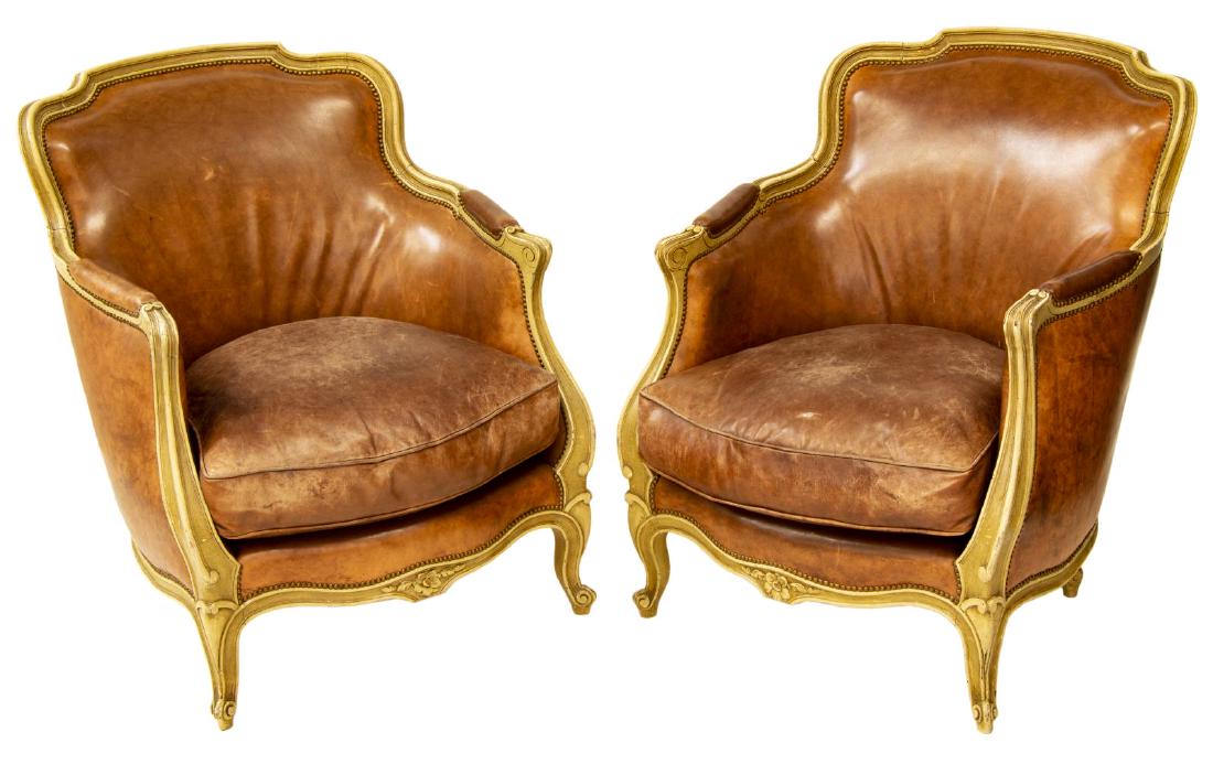(PAIR) LOUIS XV STYLE LEATHER BERGERE ARMCHAIRS: (pair) Louis XV style bergere armchairs, 20th c., having painted frame, brown leather upholstery, cushion seat, rising on cabriole legs, ending in whorl feet, approx 32.5"h, 27"w, 21"d Start Price: $2