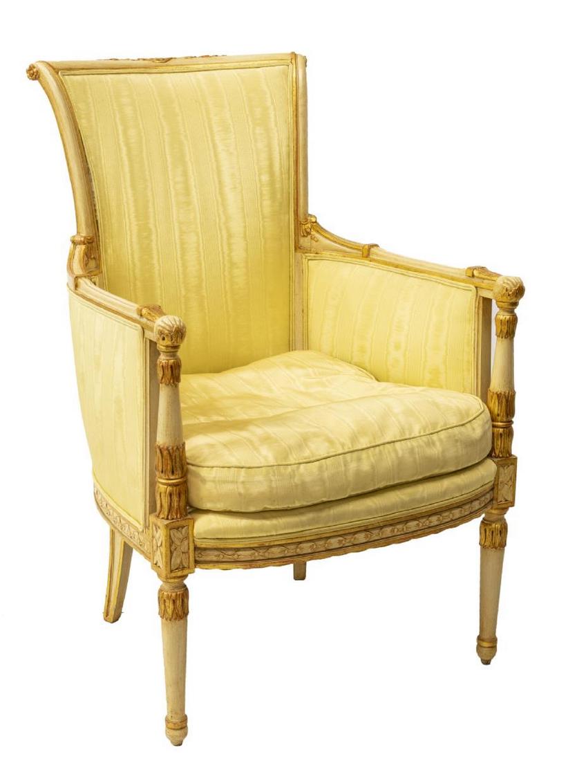 LOUIS XVI STYLE SILK MOIRE BERGERE ARMCHAIR: Louis XVI style bergere armchair, having parcel gilt painted frame, tall back, armrests with stiff leaf bands, in pale yellow silk moire upholstery, with removable seat cushion, rising on tapering leg