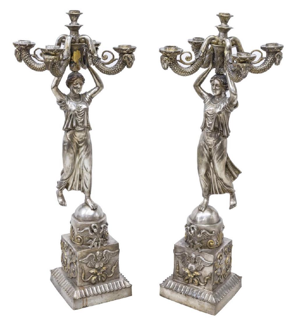 (2) SILVERED BRONZE CANEDLABRAS, 36"H: (pair) Silvered bronze five-light candelabras, 20thc., four branches ending in goat head design, supported on the head of a draped beauty balancing on one foot, rising on a pedestal decorated with ang