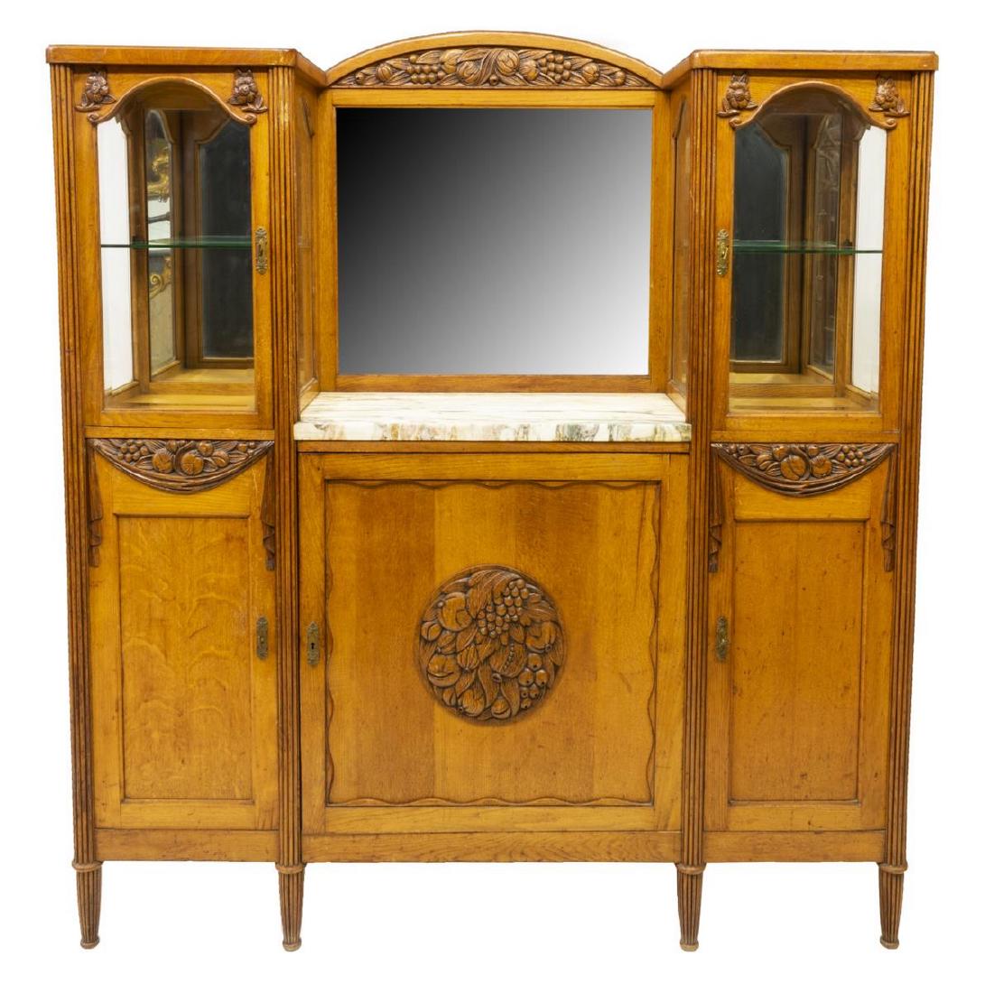 FRENCH ART NOUVEAU OAK AND MARBLE BUFFET: French Art Nouveau oak and marble buffet, late 19thc., having carved foliate and fruit design to the crest and drawers, marble top with beveled mirror backsplash flanked by two cabinets with glass wal