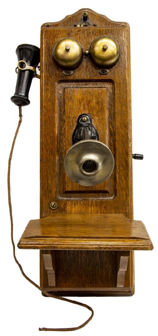 AMERICAN OAK CASED CRANK WALL TELEPHONE: American crank wall telephone, early 20th c., with oak case, dual brass bells, cast iron and brass speaker, over note shelf/ ledge, receiver present but detached, internal works appear intact, not tes