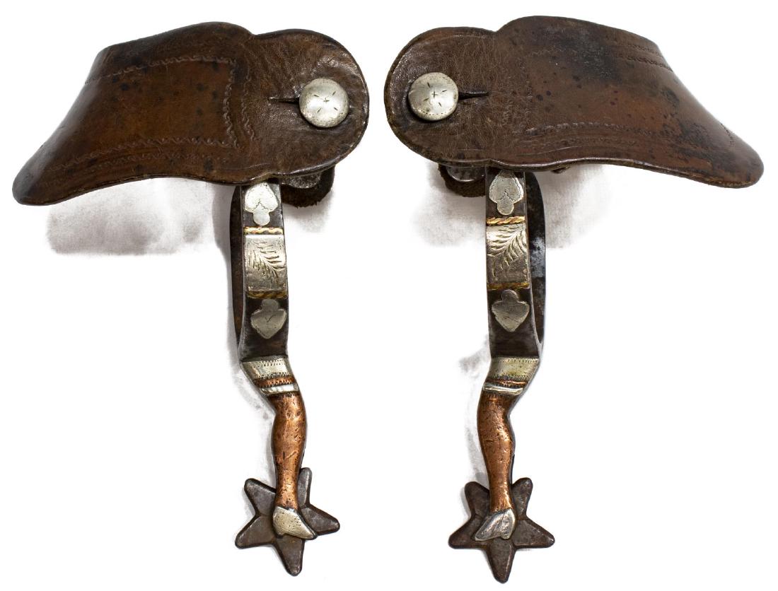 J.R. McCHESNEY NO. 8 GAL LEG SPURS: J.R. McChesney (1868-1928) No. 8 gal leg spurs c. 1918, double mounted copper and nickel, 1.25" five point star rowel, leather straps, inside yoke approx: 2.75"w, 2.75"d Start Price: $400.00