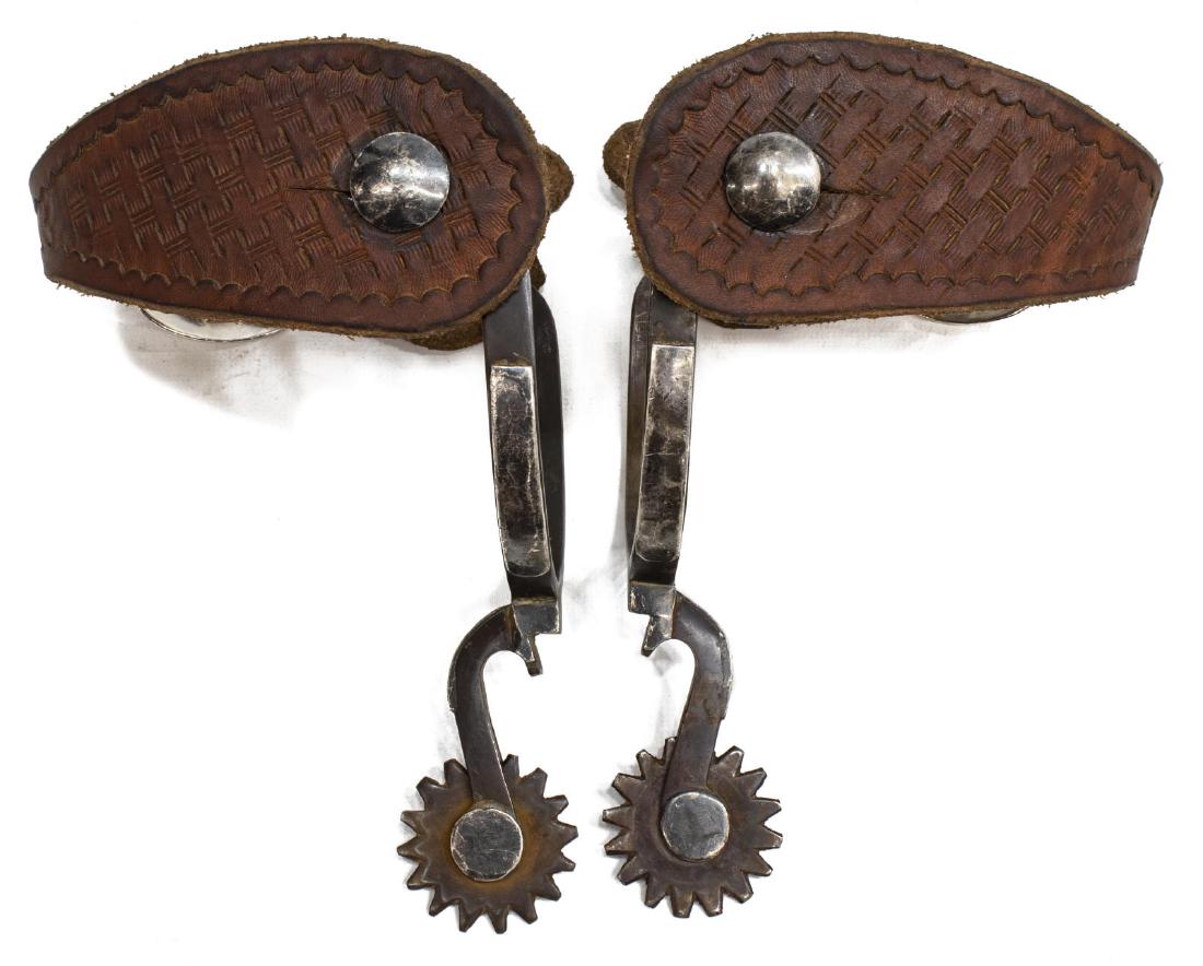 DOUBLE MOUNTED BOTTLE OPENER SPURS: Unmarked double mounted bottle opener spurs, 1.5" rowels, tooled leather straps, inside yoke approx. 3.25"w, 3"d Start Price: $250.00