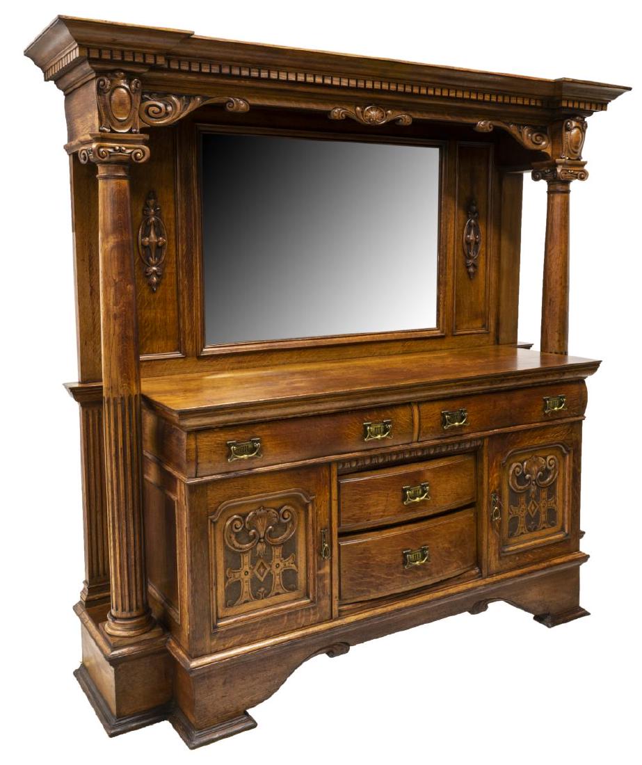 ARTS & CRAFTS OAK MIRRORED BUFFET SIDEBOARD: Arts and Crafts oak buffet, early 20th c., having cornice top with dentil molding, carved frieze, ionic column supports, raised back with beveled mirror plate, lower case fitted with two long drawers,
