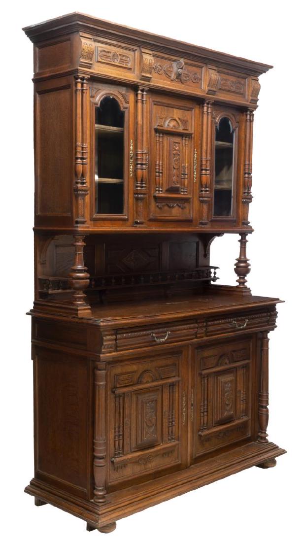 FRENCH HENRI II STYLE OAK DEUX CORPS BUFFET: French Henri II style oak deux corps buffet, late 19th c., having cornice top, carved frieze, upper cabinet fitted with three doors, left and right doors with arched beveled glass panes, on turned sup