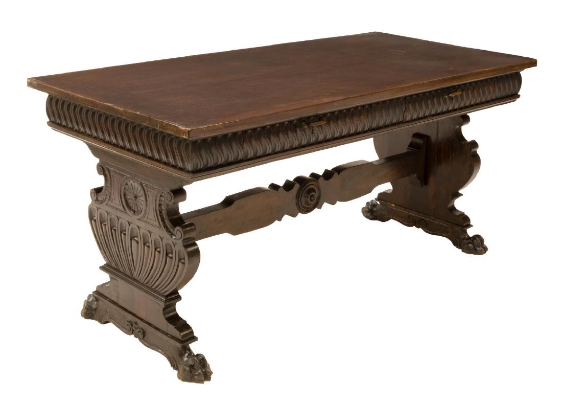 ITALIAN RENAISSANCE REVIVAL WALNUT DESK: Italian Renaissance Revival walnut desk, early 20th c., having running ornamentation, with two drawers at one side, rising on trestle legs, resting on paw feet, approx 31.25"h, 67.25"w, 31.75"d Start 