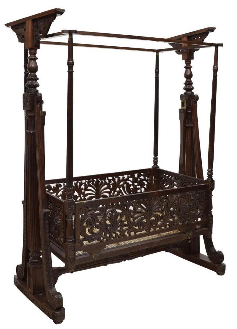ANGLO INDIAN ROSEWOOD CRADLE FOR DECORATIVE USE: Anglo Indian rosewood cradle on stand, 20th c., a large cradle with carved columns, foliate pierced carving, carved supports allowing the cradle to swing back and forth, FOE DECORATIVE USE ONLY, 75.5"