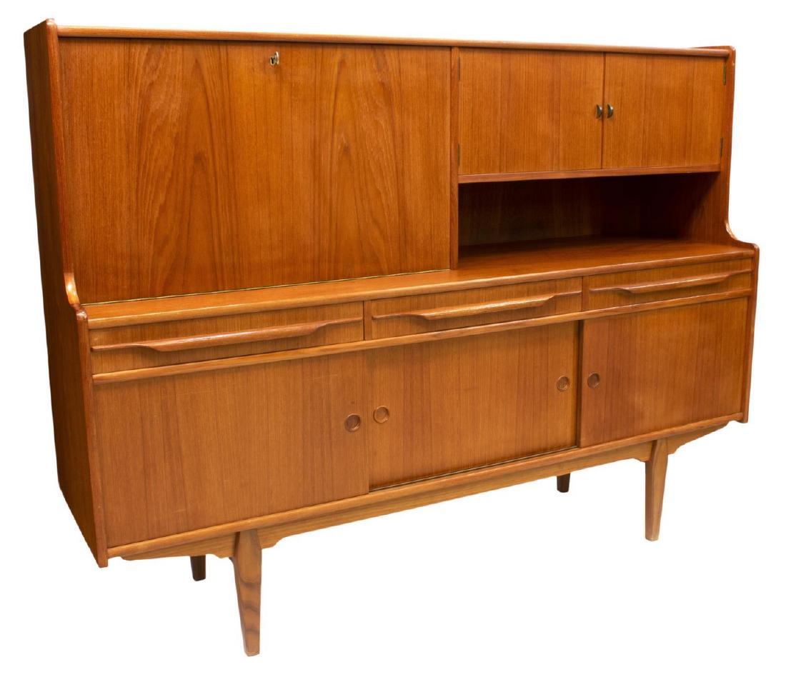 DANISH MID-CENTURY MODERN TEAK SIDEBOARD BAR: Danish mid-century modern teak sideboard, c. 1950s, having doors opening to a mirrored bar, a drop front opening to shelves and drawers, the lower section with sliding doors, all rising on tapered leg