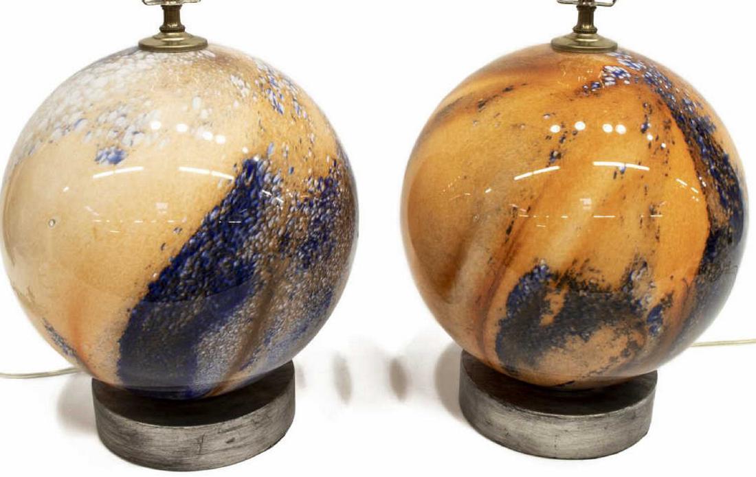 (2) COLORED ART GLASS ORB FORM TABLE LAMPS: (lot of 2) Colored art glass table lamps, 20thc., with colored orb shaped body, each rising on a circular gray base, approx measurements including harp: 24.5"h, 11.25"diam; 15.75lbs total Start Price: