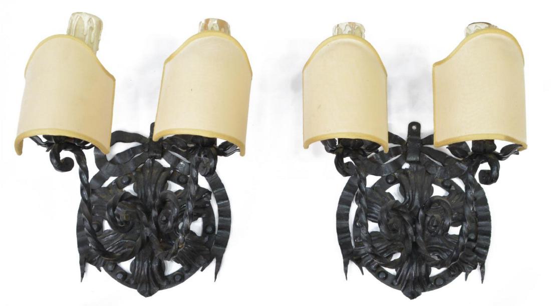 (2) ITALIAN SCROLLED BLACK IRON WALL SCONCES: (pair) Italian foliated scrolled iron sconces, early 20th c., each having two lights, some wear to shades and candle covers, in need of wiring, approx 12"h, 7.25"w, 5.5lbs Start Price: $60.00