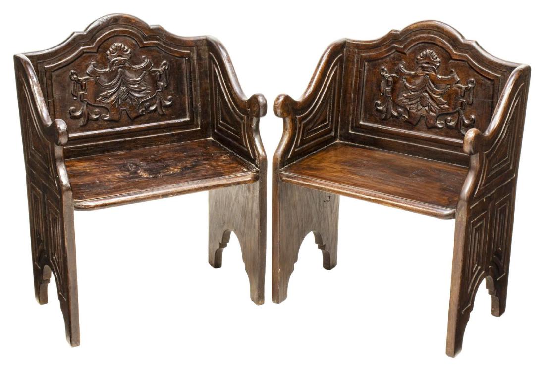 (2) ITALIAN RENAISSANCE REVIVAL LOW MONKS STOOLS: (pair) Italian Renaissance Revival low stools/ monks chairs, 19th c., having arched back, with carved central cartouche, slopping arms, flanking plank seat, shaped bracket/ bootjack legs with geometri