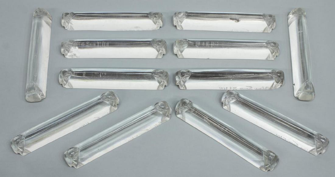 12) LALIQUE EGYPTIAN REVIVAL SCARABEES KNIFE RESTS: (lot of 12) French Egyptian Revival "Scarabees" knife rests, c. 1924, Rene Lalique (France, 1860-1945), with molded scarab beetle at each end, signed R. Lalique, France, (nine) with chips, approx 4.5"