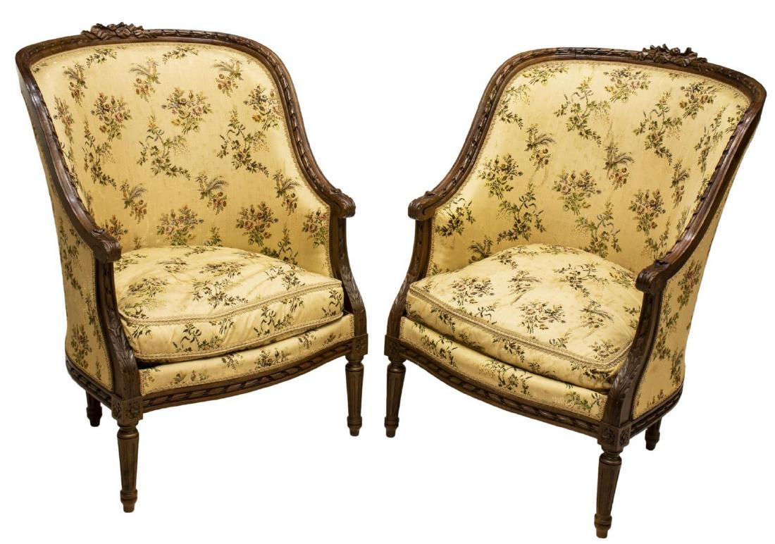 (2) FRENCH LOUIS XVI STYLE BERGERES EN GONDOLE: (lot of 2) French Louis XVI style bergeres en gondole, 19th c., carved ribbon crest, over enclosed back, removable seat cushion, scrolled foliate-carved handholds, rising on tapering fluted legs, wear