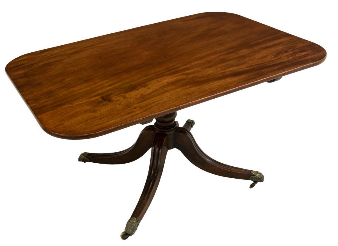 ENGLISH MAHOGANY SINGLE BOARD TILT-TOP TABLE: English mahogany tilt-top table, early to mid 19th c., having single board top with rounded corners, turned pedestal base, on four fluted legs, ending in cast metal feet caps with oak leaf and acorn m