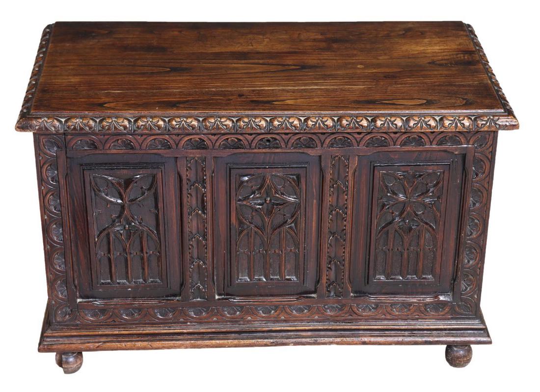 FRENCH GOTHIC REVIVAL CARVED OAK COFFER TRUNK: French Gothic Revival oak coffer, 19th c., having hinged top, open interior, elaborate carving throughout, including floral motifs and running ornamentation, resting on ball feet to front, restoration