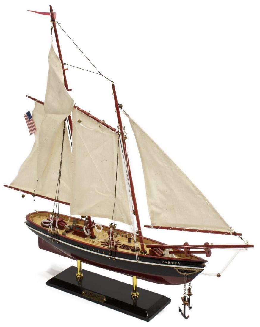 PAINTED SCALE MODEL AMERICA RACING YACHT SAILBOAT: Scale model of the racing yacht America, late 20th c., hand painted, with individual deck planks, canvas sails, all on plinth base with brass name plaque, approx 21.5"h, 21.75"w, 3.5"d, 1.25lbs Start
