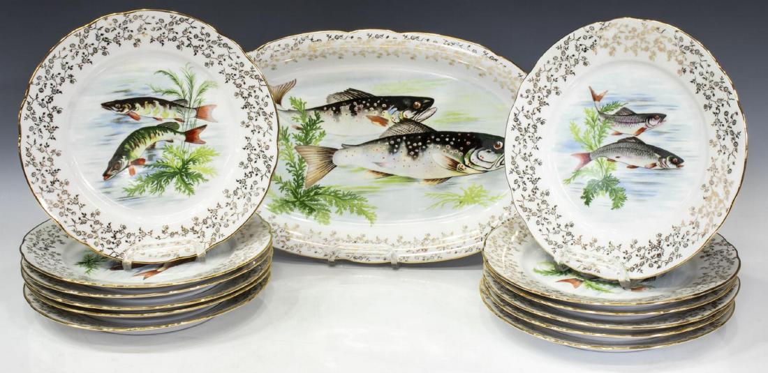 (13) SOFAFILS PARCEL GILT FISH SERVICE PLATES: (lot of 13) Sofafils porcelain plates, in a gilt floral with centered fish pattern, comprising: (1) serving platter, 15.25"l, 9.75"w, (12) dinner plates, 9.5"diam; 14.25lbs total Start Price: $60.00