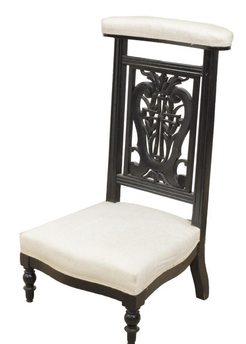 FRENCH NAPOLEON III EBONIZED WOOD PRIE DIEU: French Napoleon III prayer kneeler, late 19th c., in an ebonized finish, having openwork back with cross, scrollwork and foliate elements, rising on turned front legs, approx 35"h, 18"w, 18.25"d Start