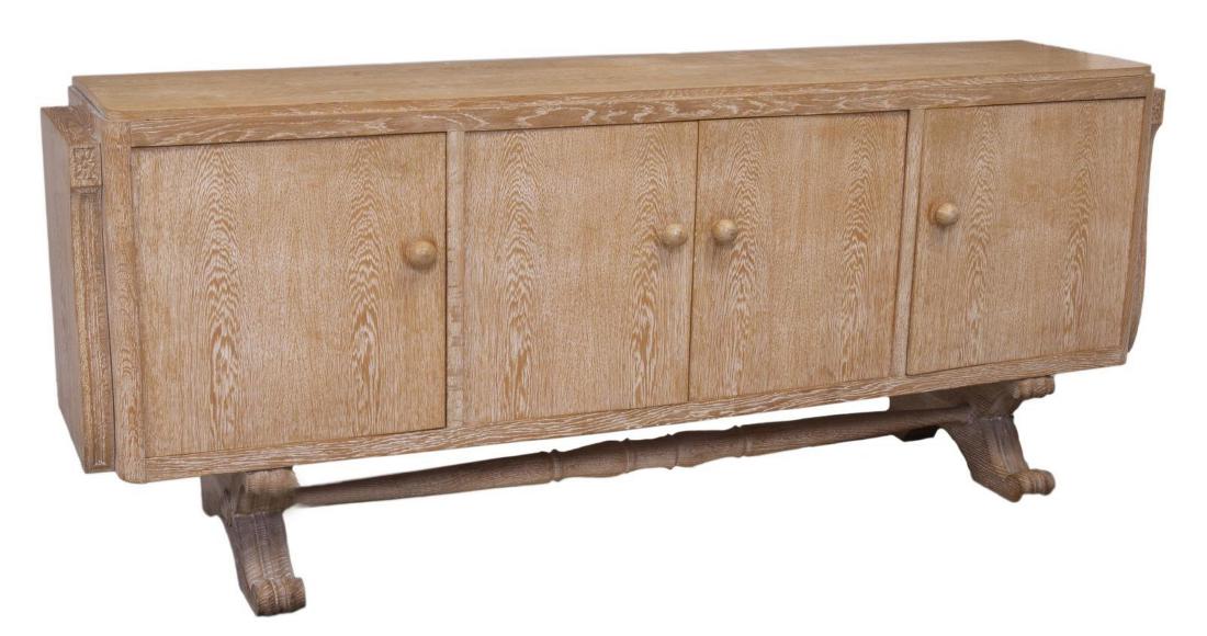FRENCH ART DECO STYLE CERUSED OAK SIDEBOARD: French Art Deco style cerused oak sideboard, mid 20th c., in the style of Jacques Adnet (France, 1901-1984), long rectangular case with rounded corner posts, fitted with four doors, with oversized bal