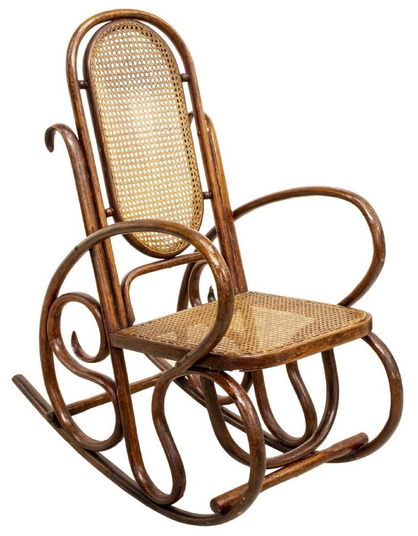 VIENNESE BENTWOOD CANE ROCKING CHAIR: Viennese bentwood rocking chair, early 20th c., in the manner of Thonet, having a caned oval back and seat, rising on a curved frame, approx 42"h, 21"w, 39"d Start Price: $100.00