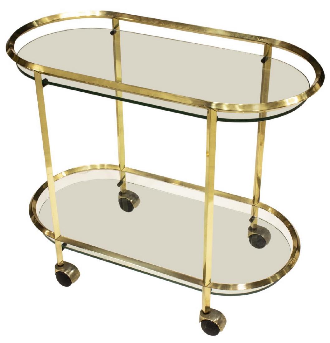 ITALIAN MODERN GILT METAL TWO-TIER SERVICE CART: Italian modern gilt metal two-tier service cart, 20th c., the oval metal railing above a glass top, above single open shelf, rising on four wheels, approx 25"h, 30"w, 15"d Start Price: $100.00