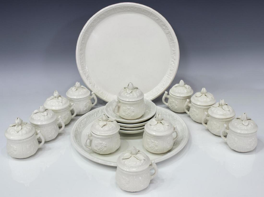(LOT) MOTTAHEDEH CREAMWARE POTS DE CREAM & TRAYS: (lot) Italian creamware pots de cream, Mottahedeh (attributed), Italy, comprising (12) lidded cups, (4) saucers, (2) circular service trays, all showing panels of foliate reliefs, lids with applied bu