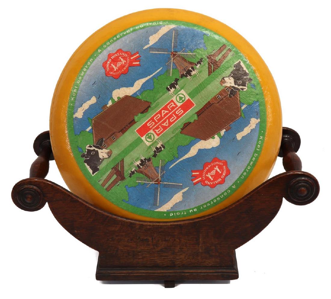 ENGLISH GEORGIAN REVOLVING CHEESE CRADLE COASTER: English Georgian oak cheese cradle/ coaster, 19th c., having bolster turned ends with applied bosses, on plinth base with rotating stand, embossed mark JC underfoot, approx 7.5"h, 17.25"l, 7.25"d, 2.5