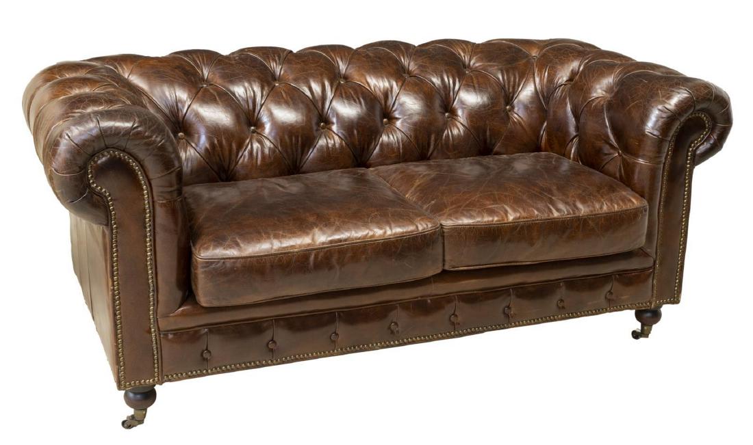 CHESTERFIELD TWO-SEAT BUTTONED LEATHER SOFA: Chesterfield two-seat sofa, 20th c., in chocolate brown leather upholstery, having button-tufted rolled back and arms, rising on turned legs on casters, approx 31.5"h, 68"w, 35"d Start Price: $300.00
