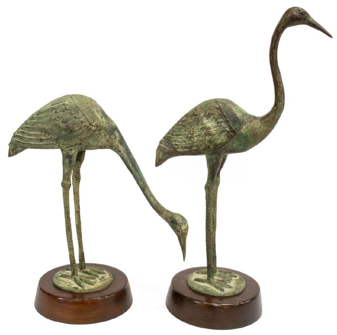 (2) VERDE PATINATED BRONZE CRANES ON WOOD BASES: (lot of 2) Verde patinated bronze figures, each modeled as crane in varied standing pose, upon a circular wood base, largest: approx 23.5"h, 7"w; 15.25lbs total **Provenance: From the Estate of Huey K