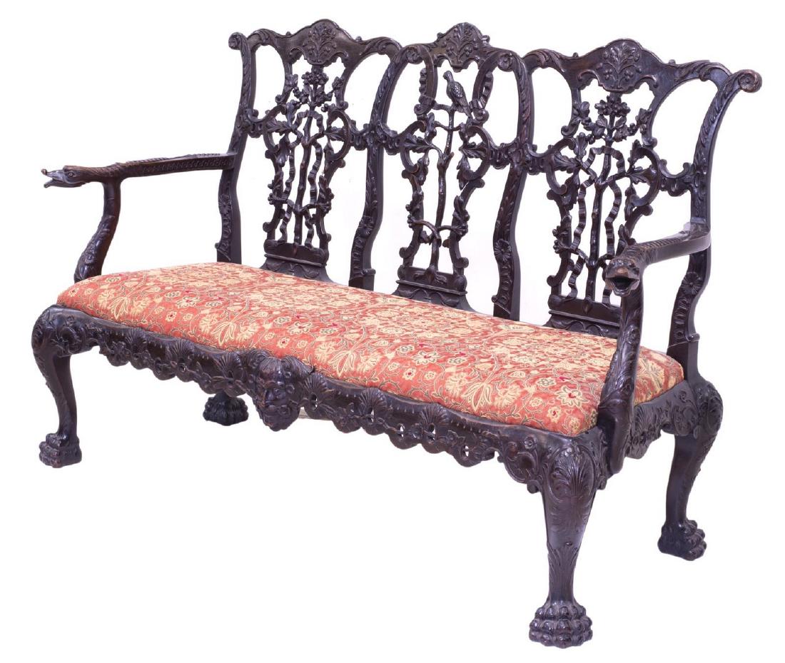 ORNATE & HIGHLY CARVED CHIPPENDALE SETTEE: Chippendale settee, 19th c., a shaped crest rail over the pierced ribbon back splats accented with foliate carving and a centered carved bird, curving arms with dolphin head terminals flank the seat c