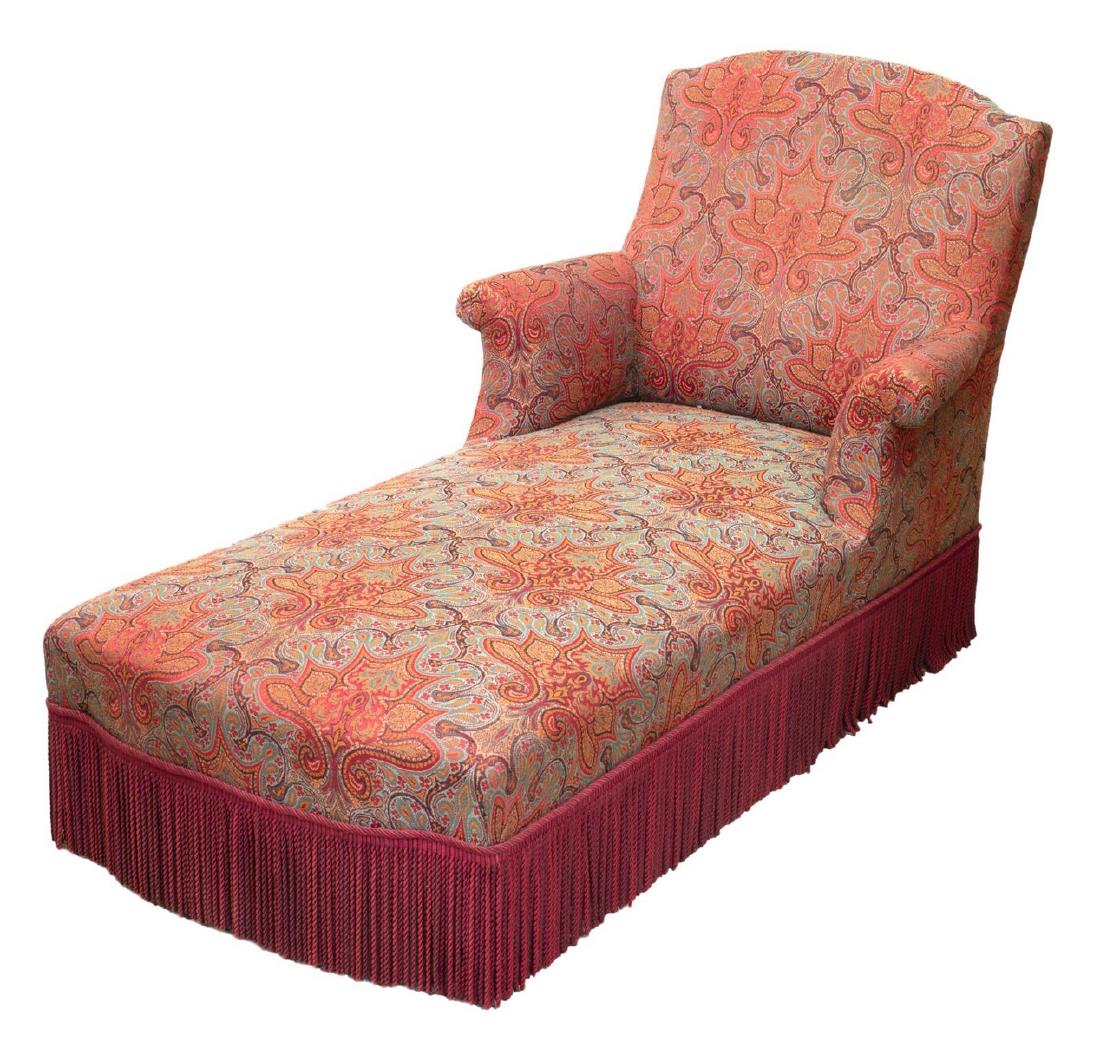 FRENCH NAPOLEON III UPHOLSTERED CHAISE LOUNGE: French Napoleon III chaise lounge, late 19th c., having tall back, rolled arms, long bench seat, in later paisley upholstery, fringe skirt concealing front turned legs, approx 36"h, 56"l, 32"w Start P