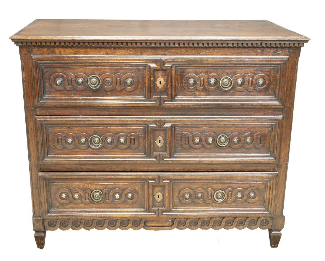 VERY FINE LOUIS XVI STYLE CARVED OAK COMMODE: Very fine Louis XVI style carved oak commode, 19th c., accented by dentils around top and running ornamentation throughout, having three drawers, brass hardware of varied styles, rising on tapered flu
