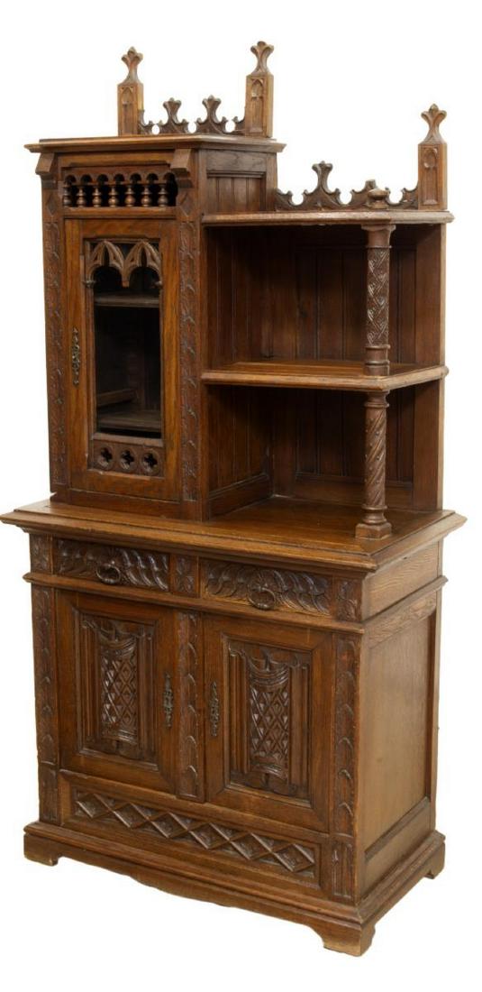 DIMINUTIVE FRENCH GOTHIC REVIVAL OAK BUFFET: Diminutive French Gothic Revival oak buffet, late 19th c., carved spires over glazed door with pointed arch molding and quatrefoil roundels, flanked by open shelves on carved column supports, lower ca