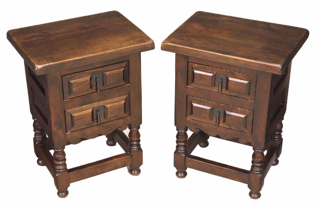(PAIR) SPANISH LOW SIDE TABLES NIGHTSTANDS: (pair) Spanish low side tables/ stands, 20th c., in a walnut finish, overhanging rectangular top, over case fitted with two drawers, paneled drawer fronts and sides, rising on turned legs, joined by b