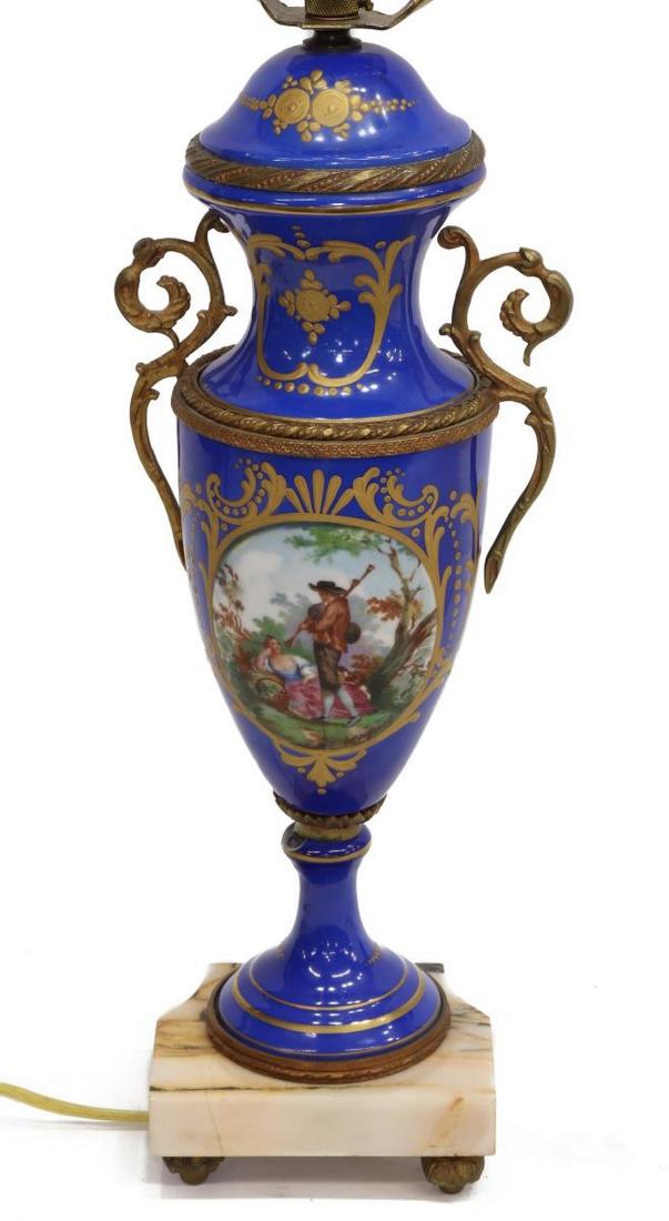 SEVRES STYLE HAND-PAINTED FIGURAL SCENE TABLE LAMP: Sevres style porcelain urn, now fashioned as a single light table lamp, having a blue ground, hand-painted figural courting scene in reserve, signed "Brommel," scrolled gilt handles, rising on a shape