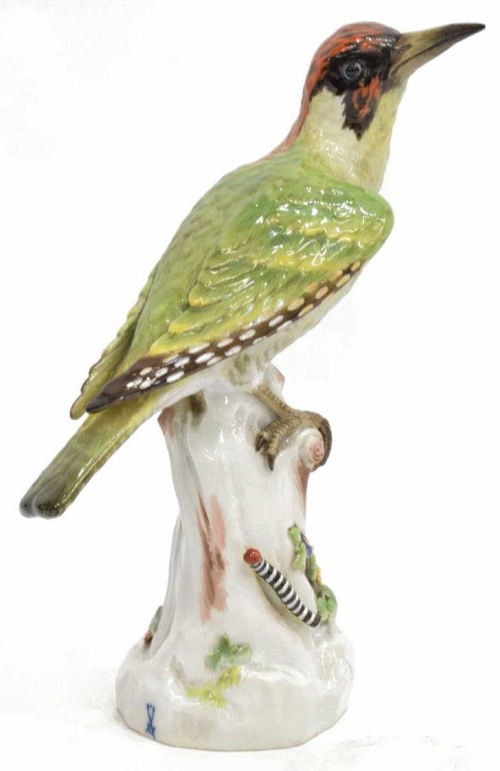 GERMAN MEISSEN PORCELAIN BIRD WOODPECKER: Meissen porcelain bird figure, Woodpecker, perched on naturalistic base, with blue crossed swords mark at base, retains retailer label for Erich Bauch in Berlin, loss to caterpillar at base, professio