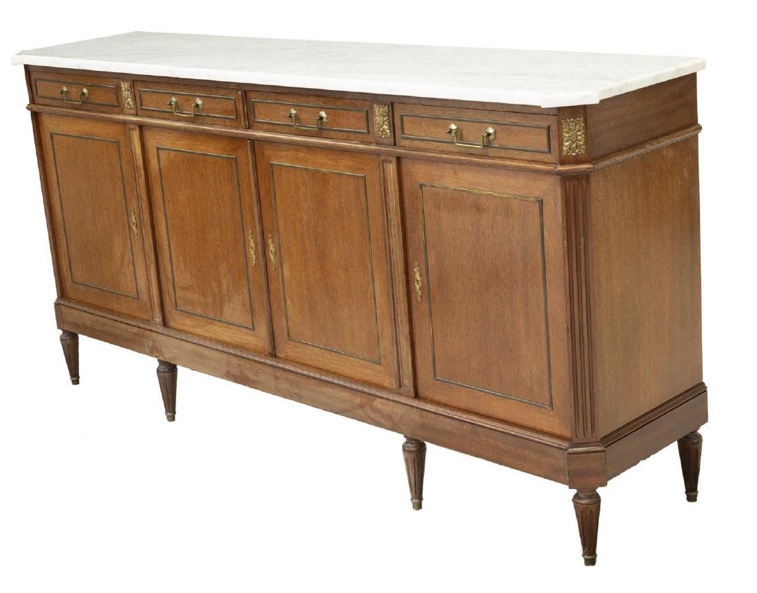 FRENCH LOUIS XVI STYLE MARBLE-TOP SIDEBOARD: French Louis XVI style sideboard, 19th c., the marble top with canted front corners over ribbed pilasters flanking four drawers over four doors, all rising on tapered ribbed legs with brass capped fee