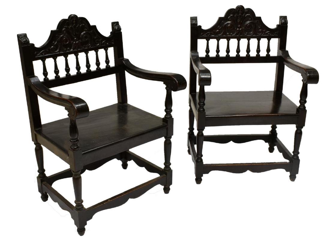 (2) SPANISH BAROQUE STYLE ARMCHAIRS: (pair) Spanish Baroque style ebonized wood armchairs, late 19th c., each high back with carved floral design, atop a wide seat on turned legs, joined by box stretcher, approx 36.75"h, 24"w, 21"d Start