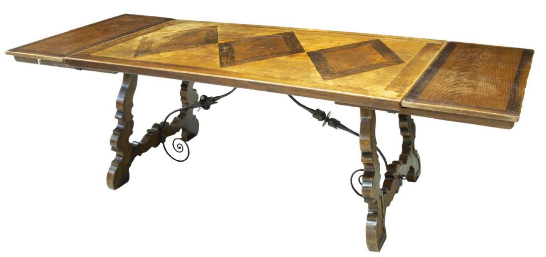 SPANISH PARQUETRY TOP EXTENSION DINING TABLE: Spanish Baroque style extension dining table, early 20th c., having parquetry elements to tabletop, rising on shaped ox yoke supports, joined by scrolled iron stretcher with foliate accent, accompanie