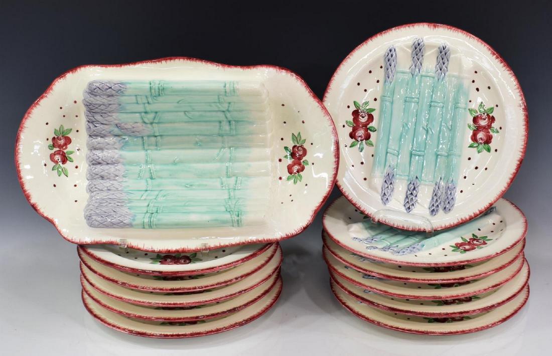 (12) FRENCH LONGCHAMP FAIENCE ASPARAGUS SERVICE: (lot of 12) French Longchamp faience asparagus service, decorated with molded asparagus and polychrome floral sprays, including: (1) serving cradle, approx 15.25"l, 9"w, (11) individual plates, two wi